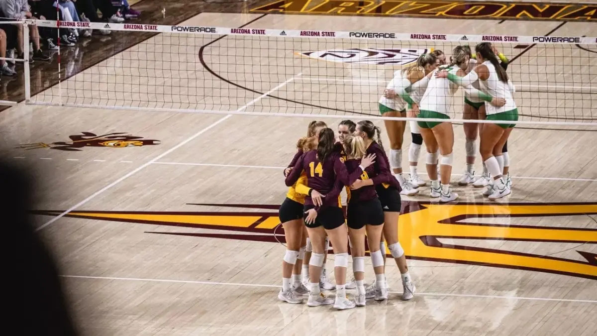 Photo by: Julia Jacome<br />
both volleyball team in team huddles