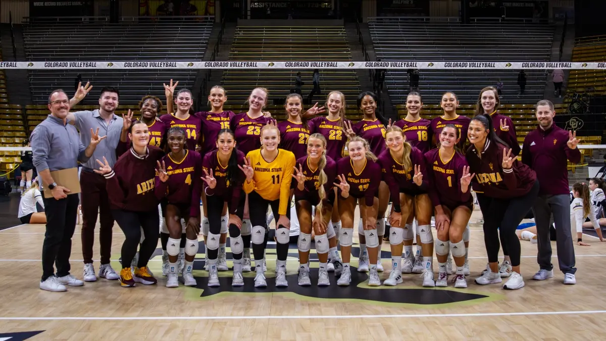 Volleyball team and staff posing together and doing forks up. Volleyball team and staff posing together and doing forks up.