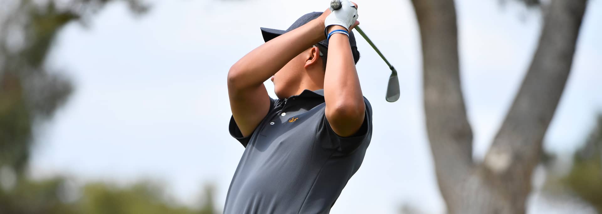 A student golf player after taking a shot.