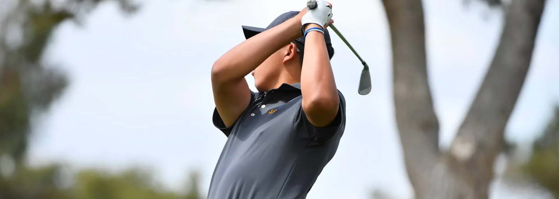 A student golf player after taking a shot.