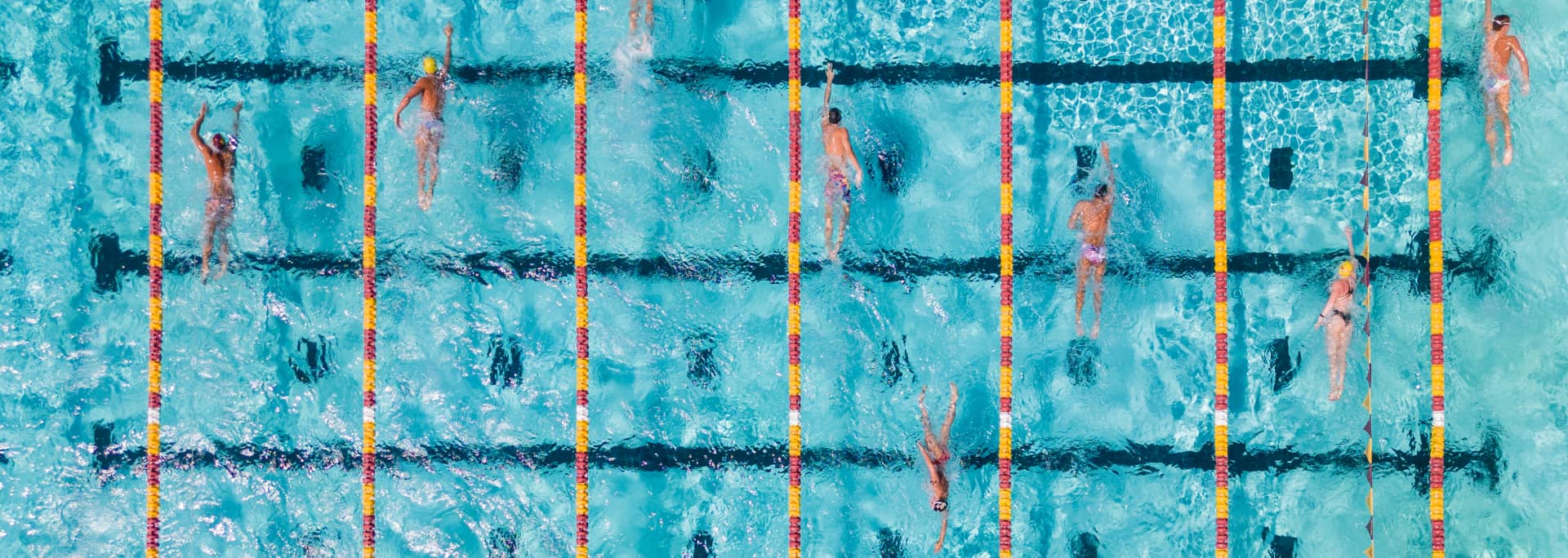 An overhead photo of the ASU pool showing ASU swimmers swimming through the lanes.