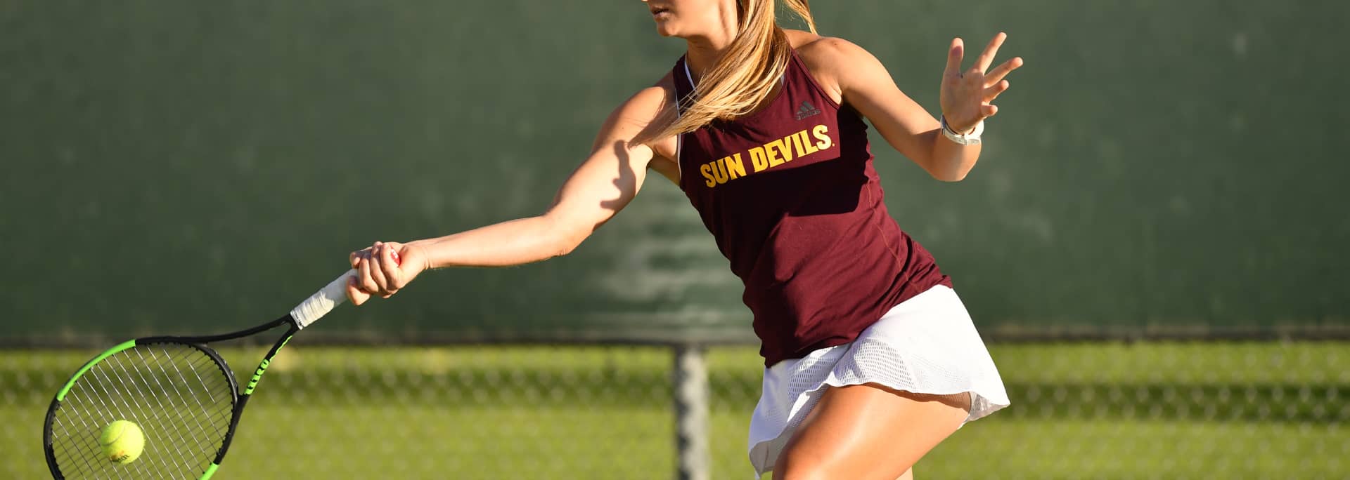 An ASU tennis player hits a tennis ball during a match.