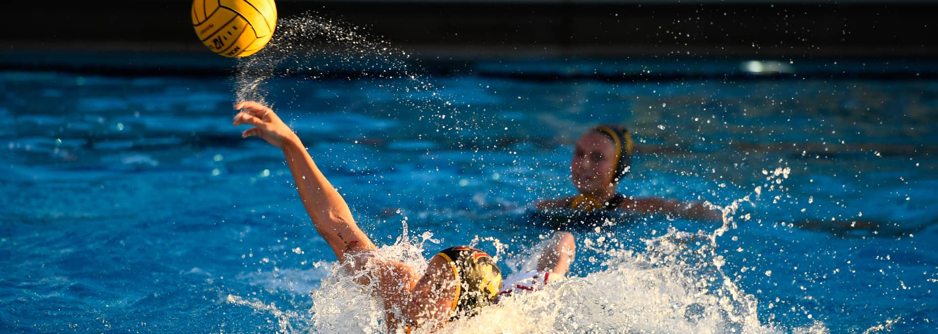 A photo of the middle of water polo game, with an ASU player throwing the ball.