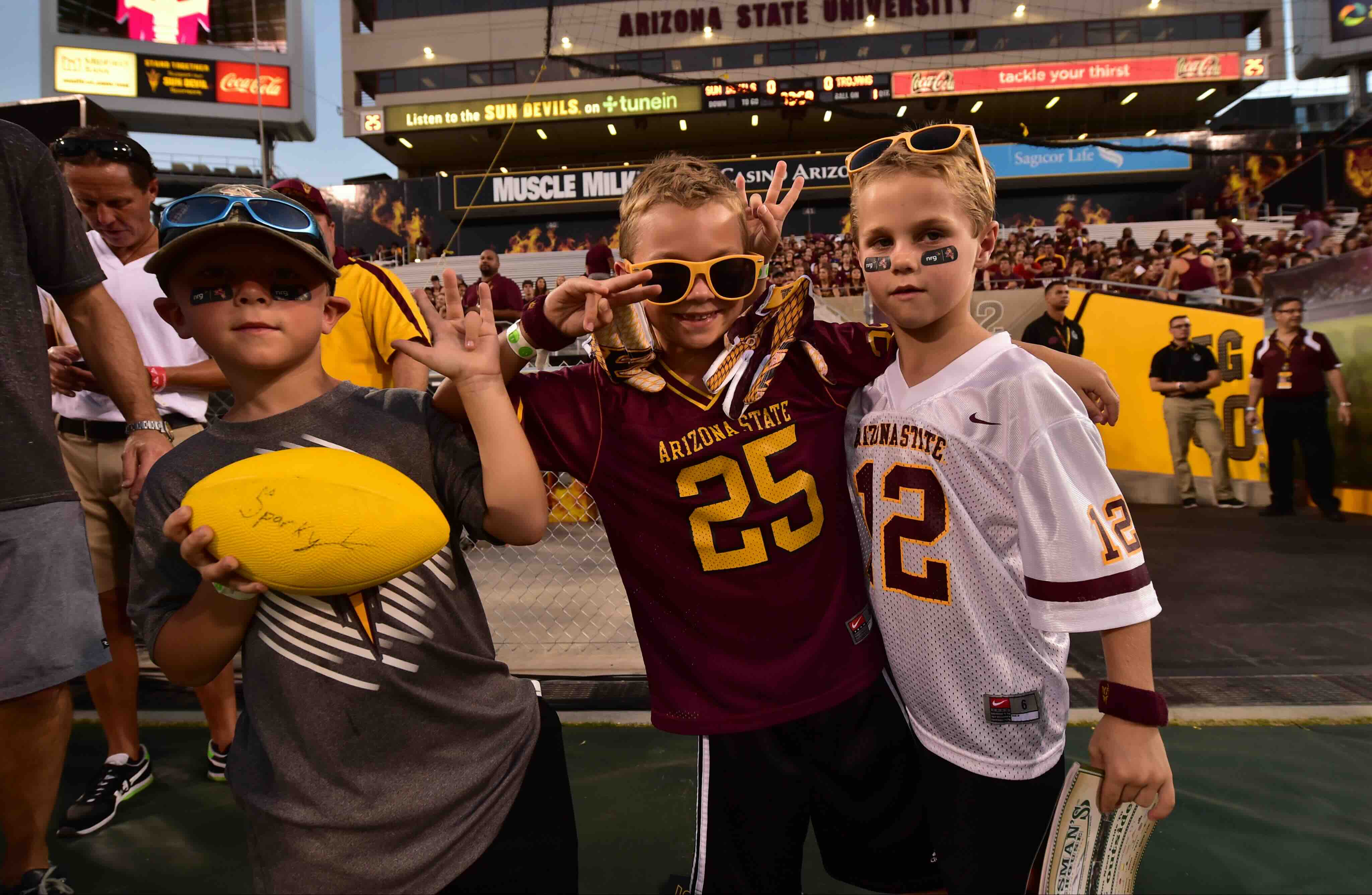 Kids in Sun Devil gear holding football at game