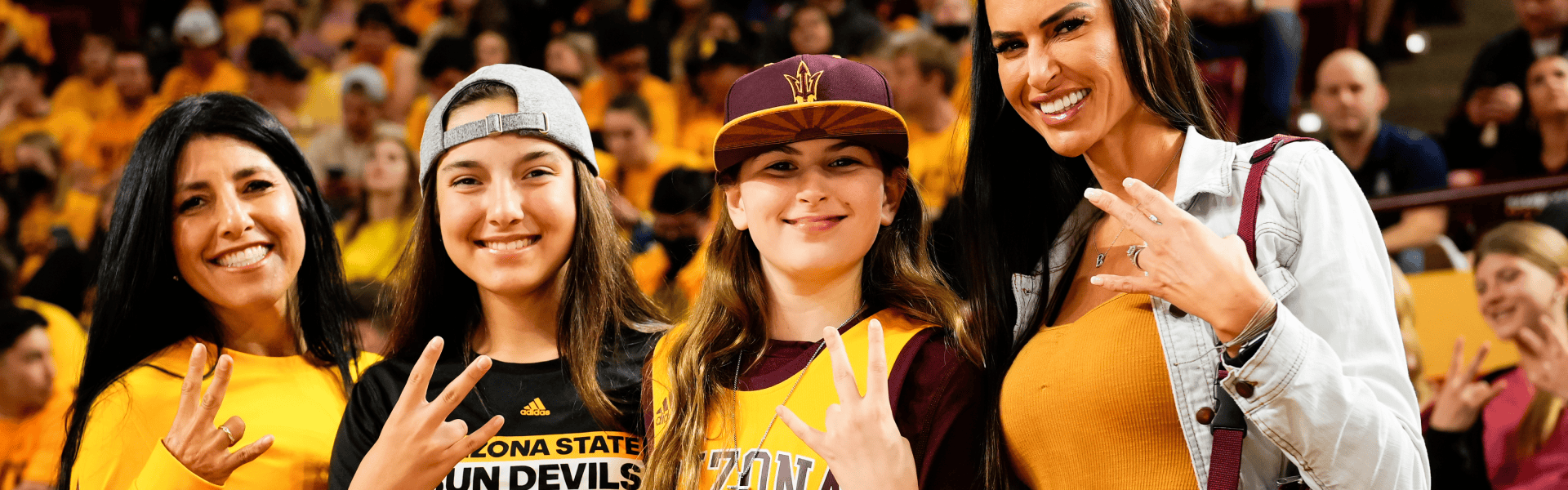 Mom with kids holding up hand pitchfork sign wearing ASU merchandise