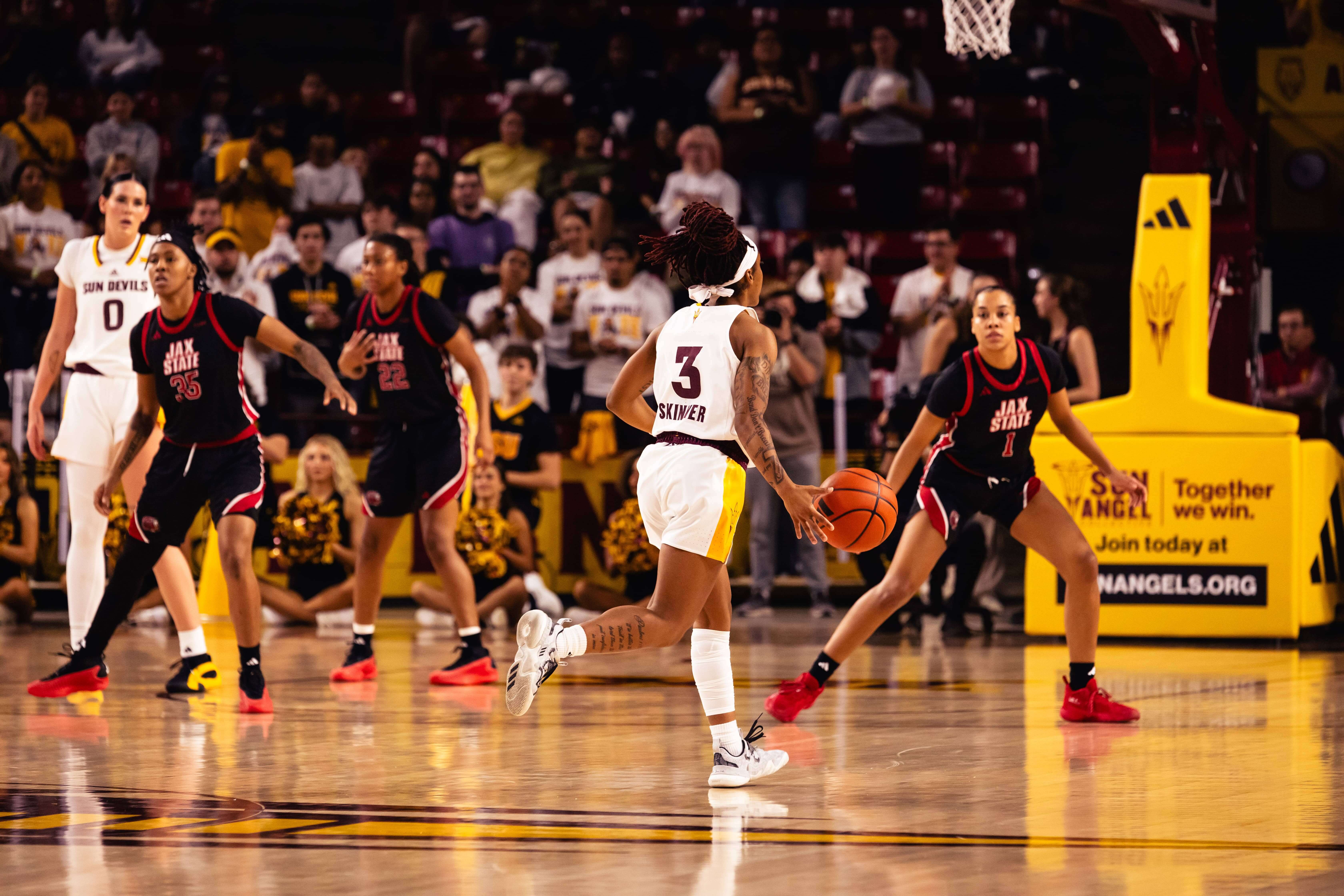 Skinner running down the court for women's basketball with ball against Jax State