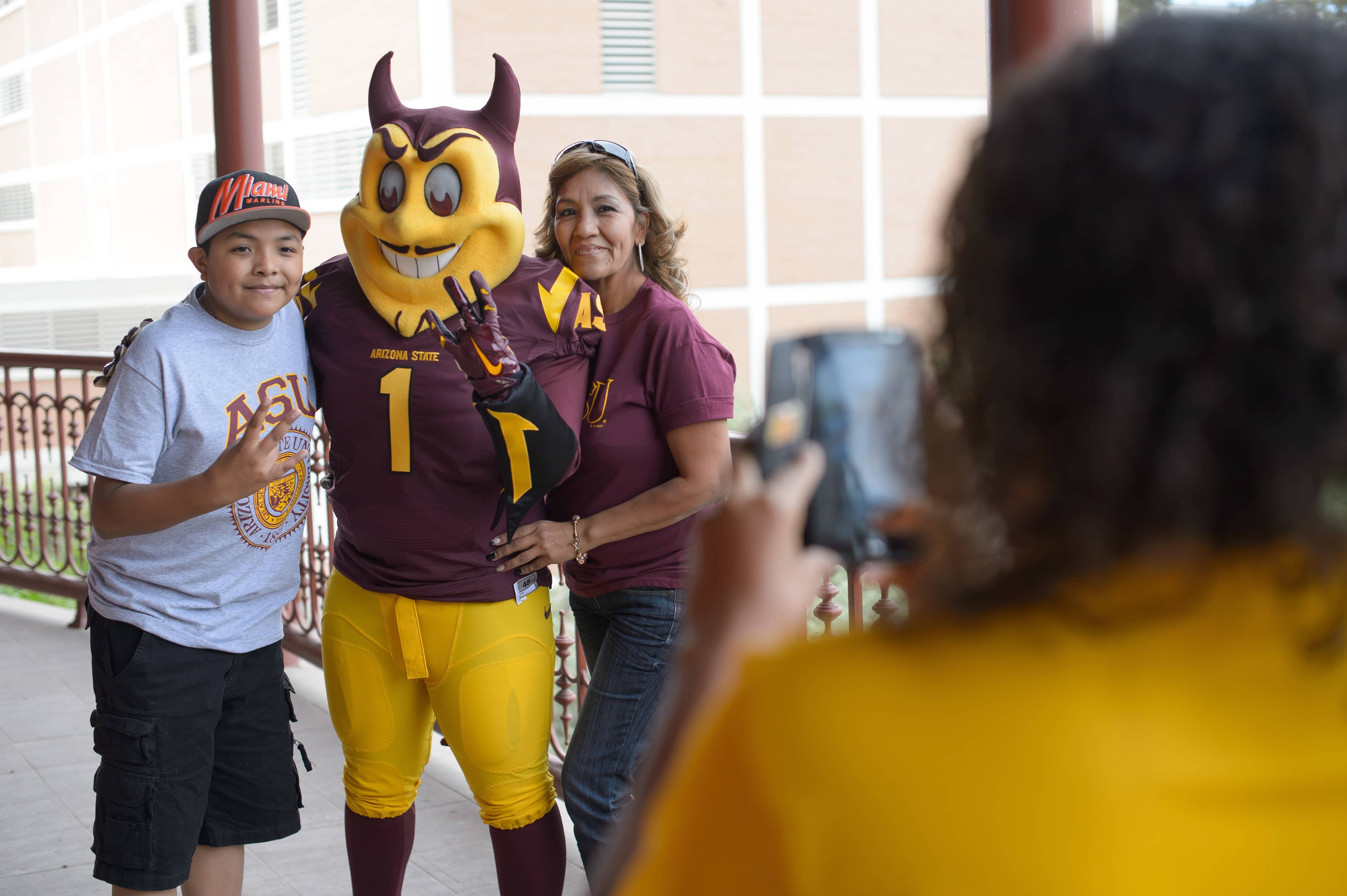 Fans posing with Sparky in ASU gear