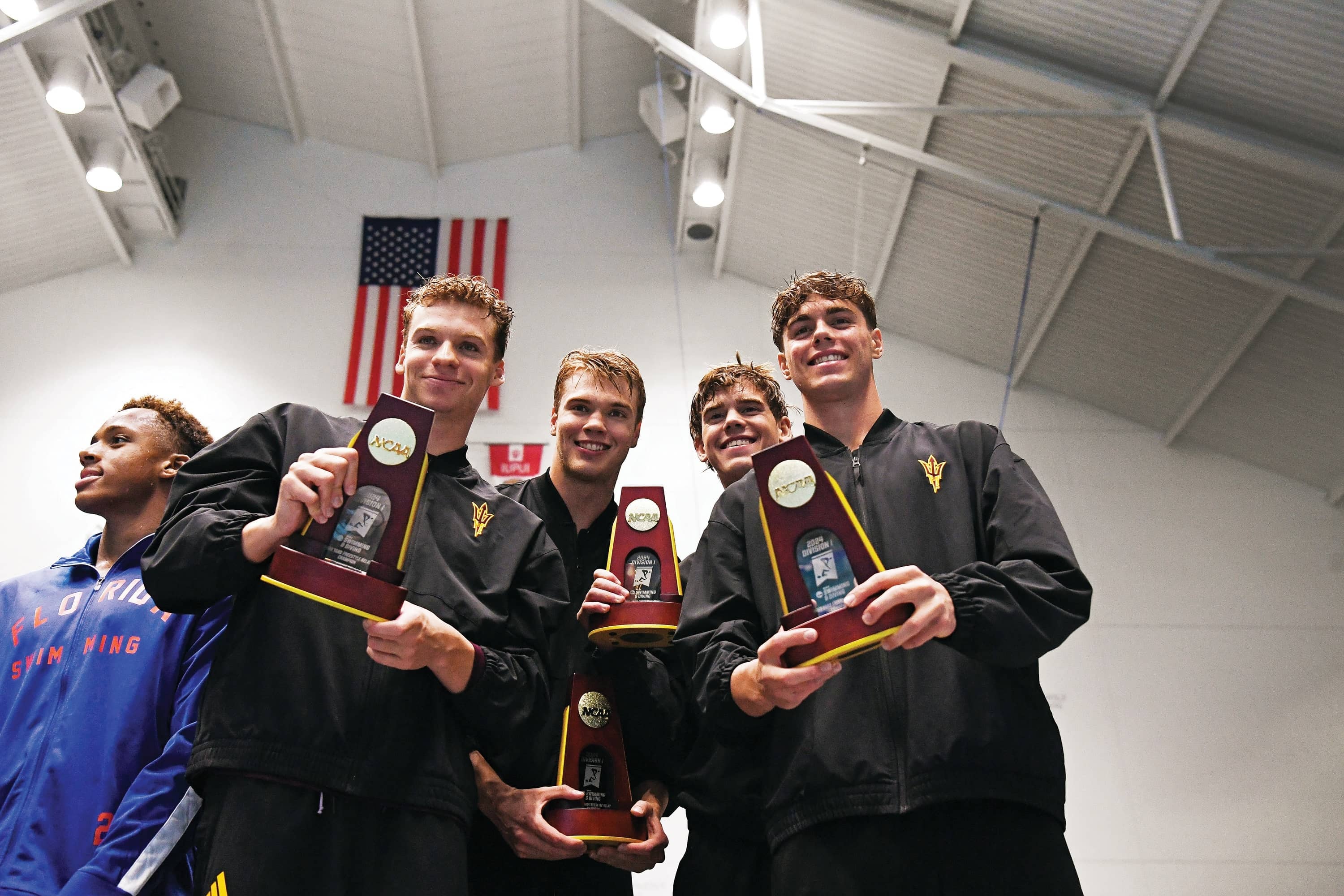 NCAA swim and dive champions holding trophy