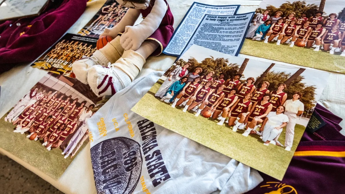 Photographs of women&#039;s basketball teams and other memorabilia sit on a table