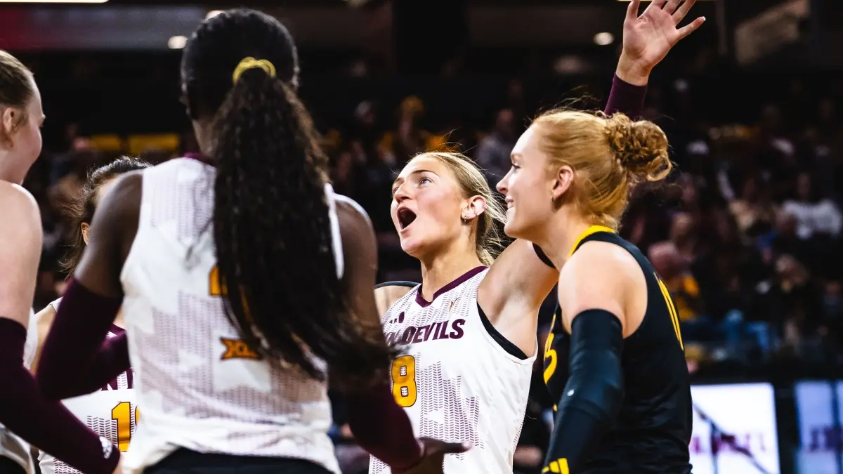 Geli Cyr throws her arms up in celebration while her team gathers around her. Geli Cyr throws her arms up in celebration while her team gathers around her.