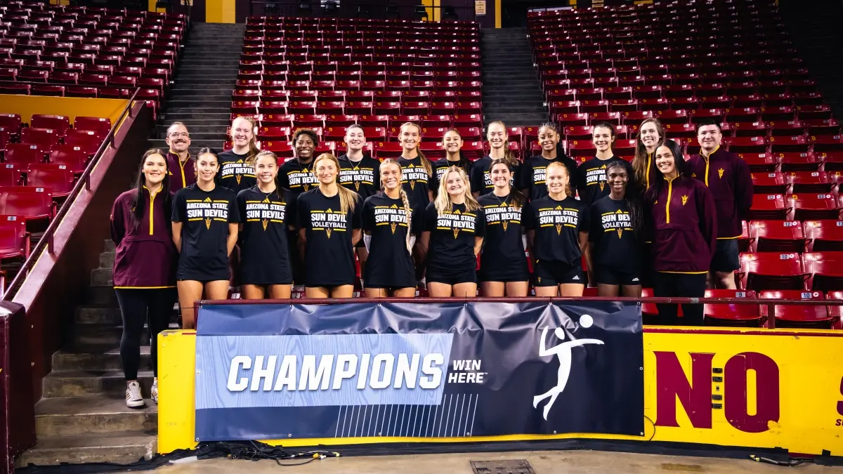 2024 volleyball team posing in front of an NCAA banner.