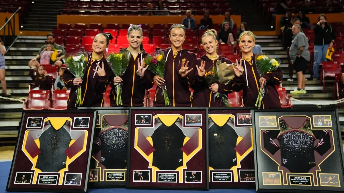 The five gymnastics seniors pose together with their flowers and frames.