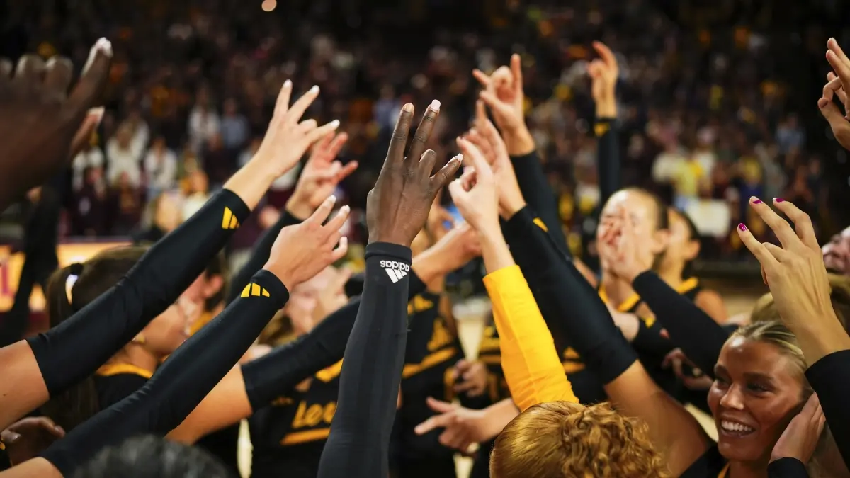 Volleyball players putting their hands up with forks up.