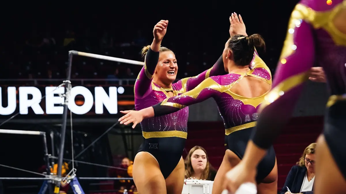 Lila Purler smiles and hugs her teammate after performing on floor. Lila Purler smiles and hugs her teammate after performing on floor.