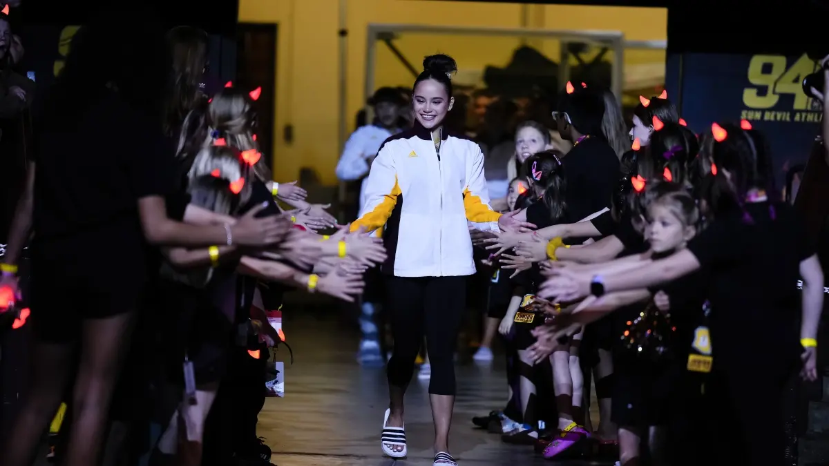 Emily White walks through a tunnel of fans, handing out high fives. Emily White walks through a tunnel of fans, handing out high fives.