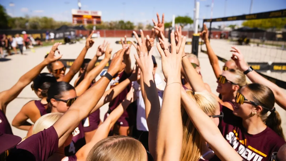Beach volleyball team huddling with their hands in the middle. Beach volleyball team huddling with their hands in the middle.