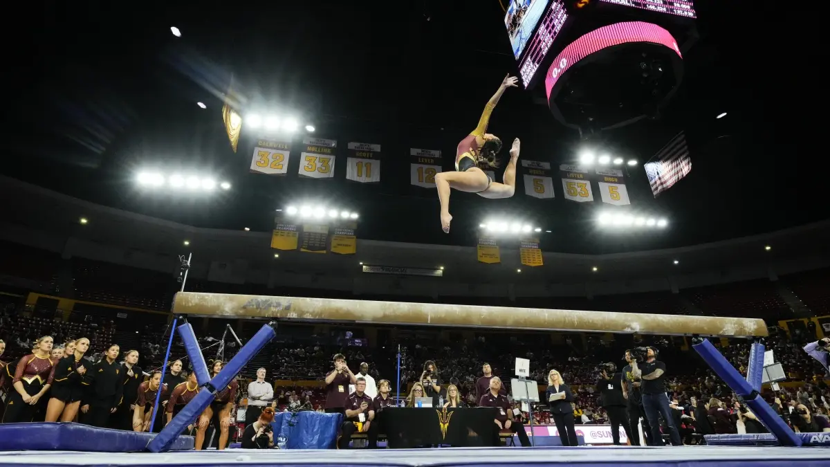 Emily White doing a leap on beam.