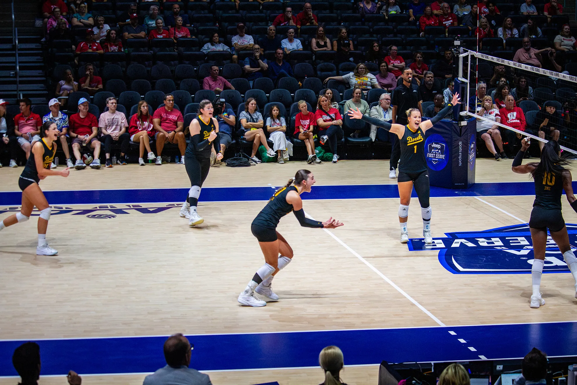 The volleyball team cheering after winning a point.