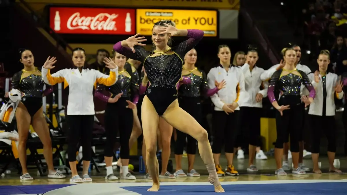 gymnast smiling with hands up 