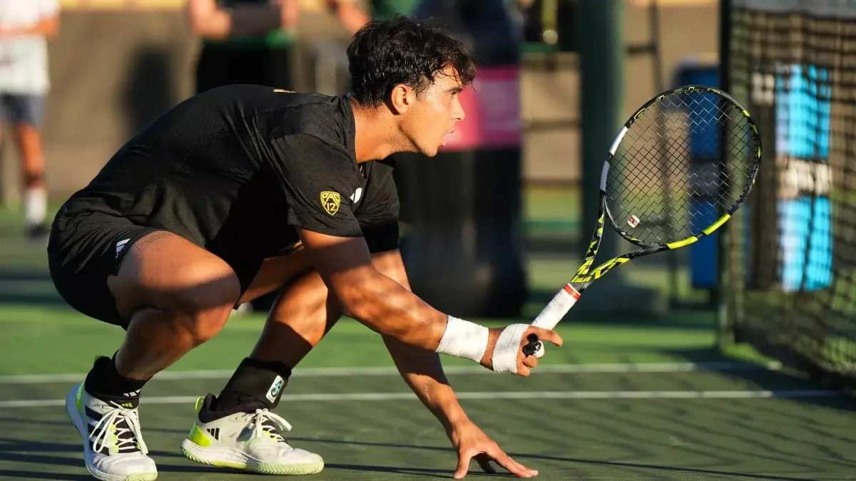 tennis player squatting during game holding racket