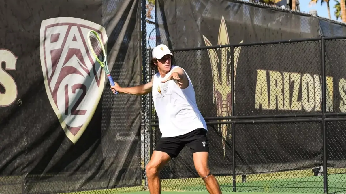 male tennis player holding racket behind his arm male tennis player holding racket behind his arm