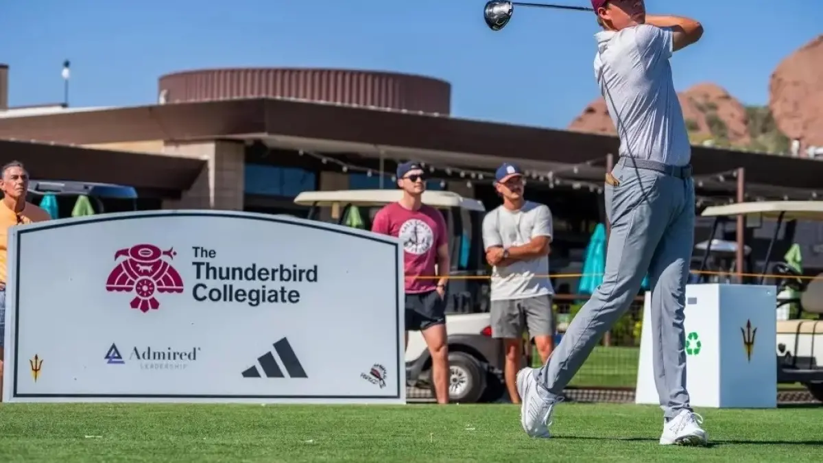 golfer swinging club in front of sign golfer swinging club in front of sign