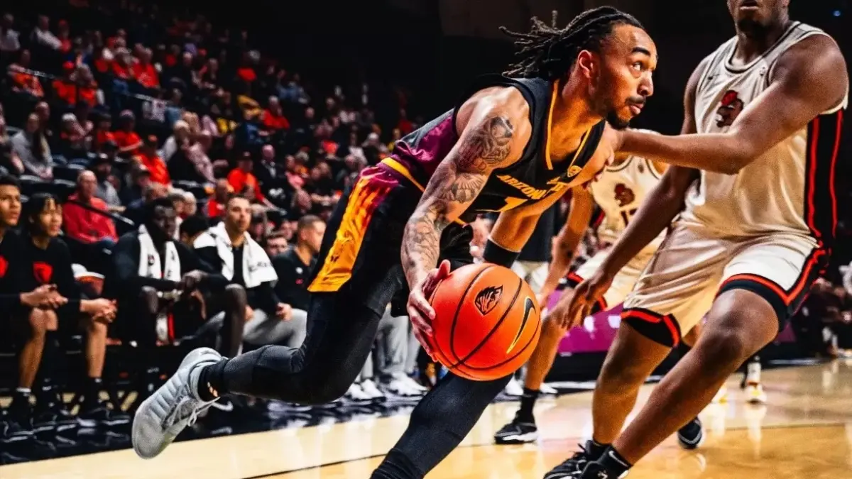 basketball player dribbling ball around opponent 