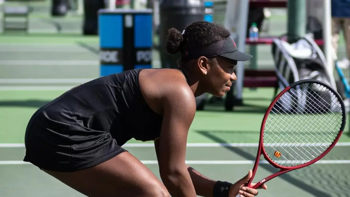 tennis player squatting during game holding racket tennis player squatting during game holding racket