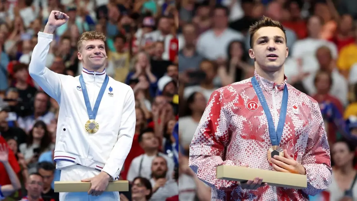 Photo by: Getty Images<br />
Léon Marchand (left) raising his fist in victory after winning gold, Ilya Kharun (right) looking into the crowd after earning bronze in the 200m fly. two male swimmers at the olympics