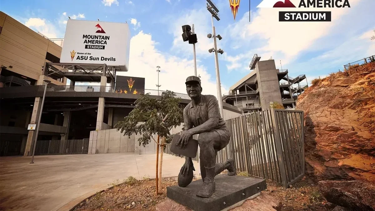 Image from ASU News stone statue of man kneeling with football in hand