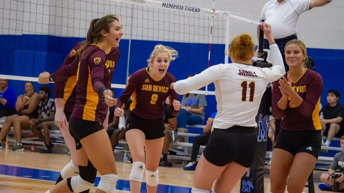 Photo by: Kimberlie Haner<br />
five volleyball players on court celebrating