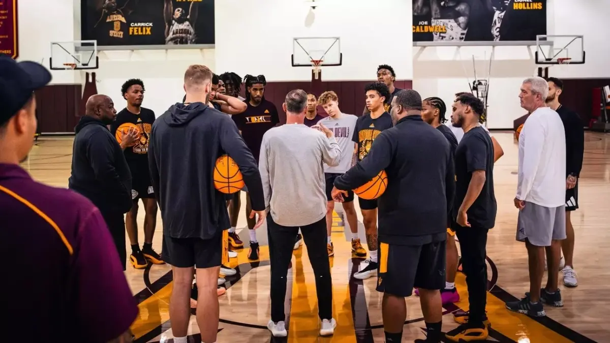 men&#039;s basketball team huddled around coach