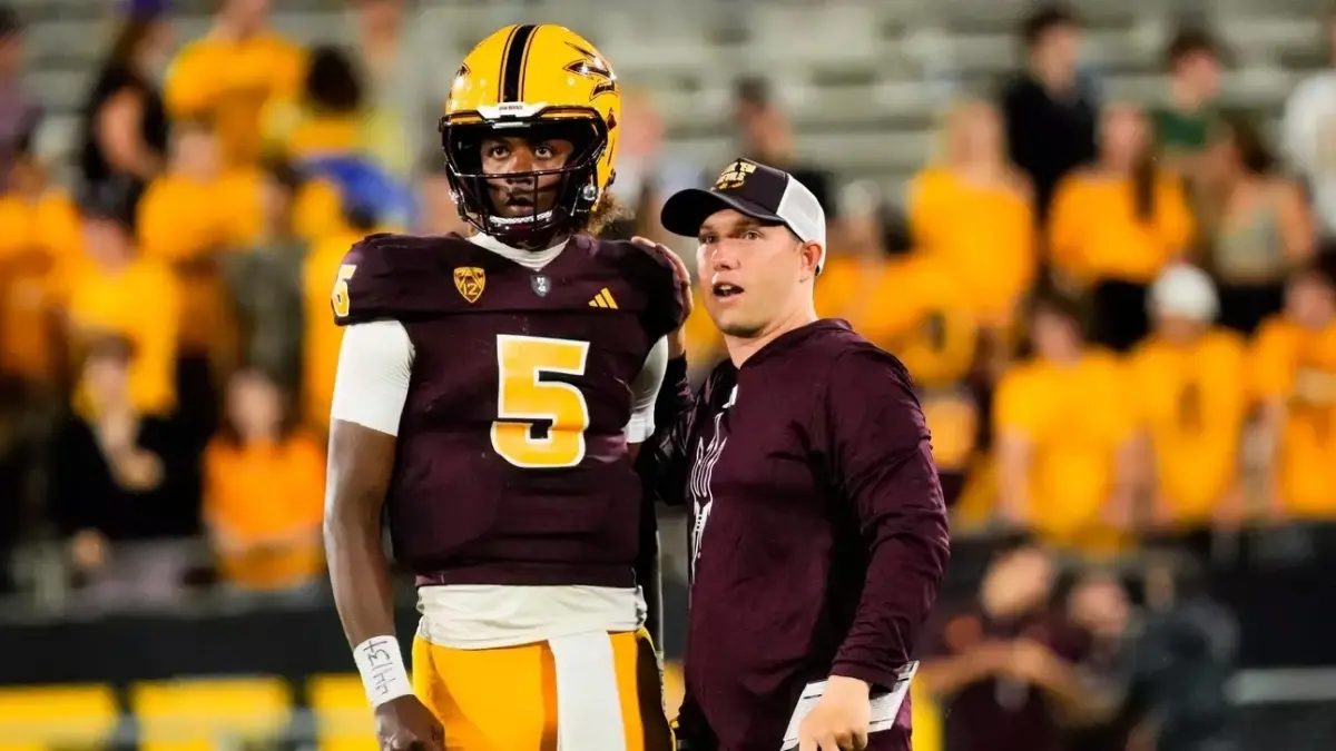 Image from ASU News coach next to player looking at field