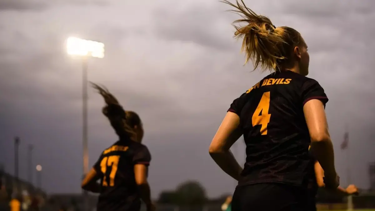 two soccer players running two soccer players running
