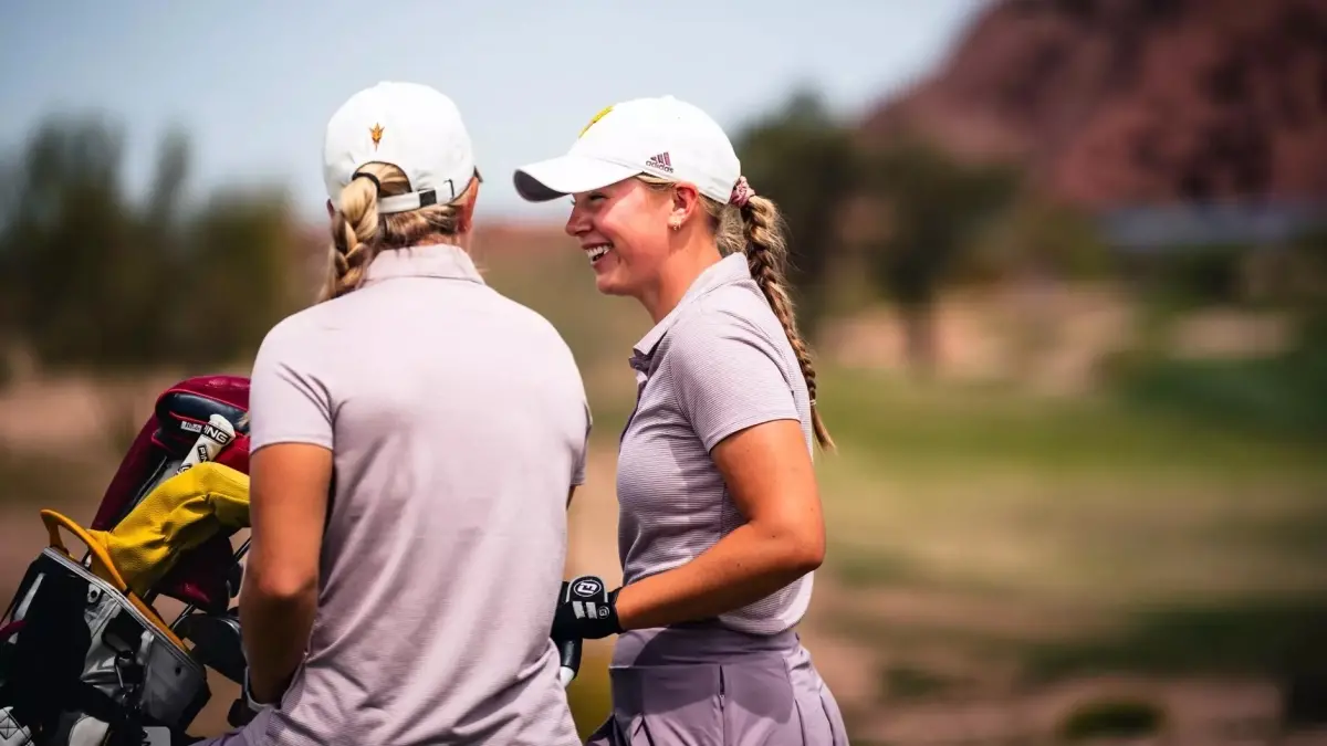 two women golf players walking