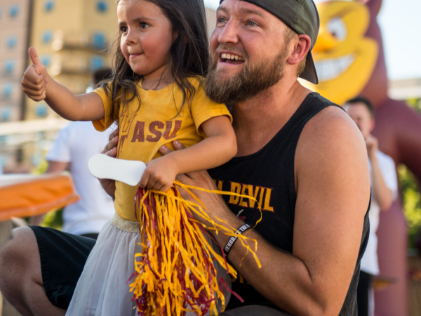 Smiling dad and daughter dressed in ASU Sun Devil gear