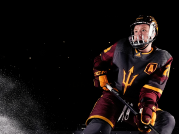 Sun Devil Ice Hockey player skating on his skates with ice coming from behind with his stick